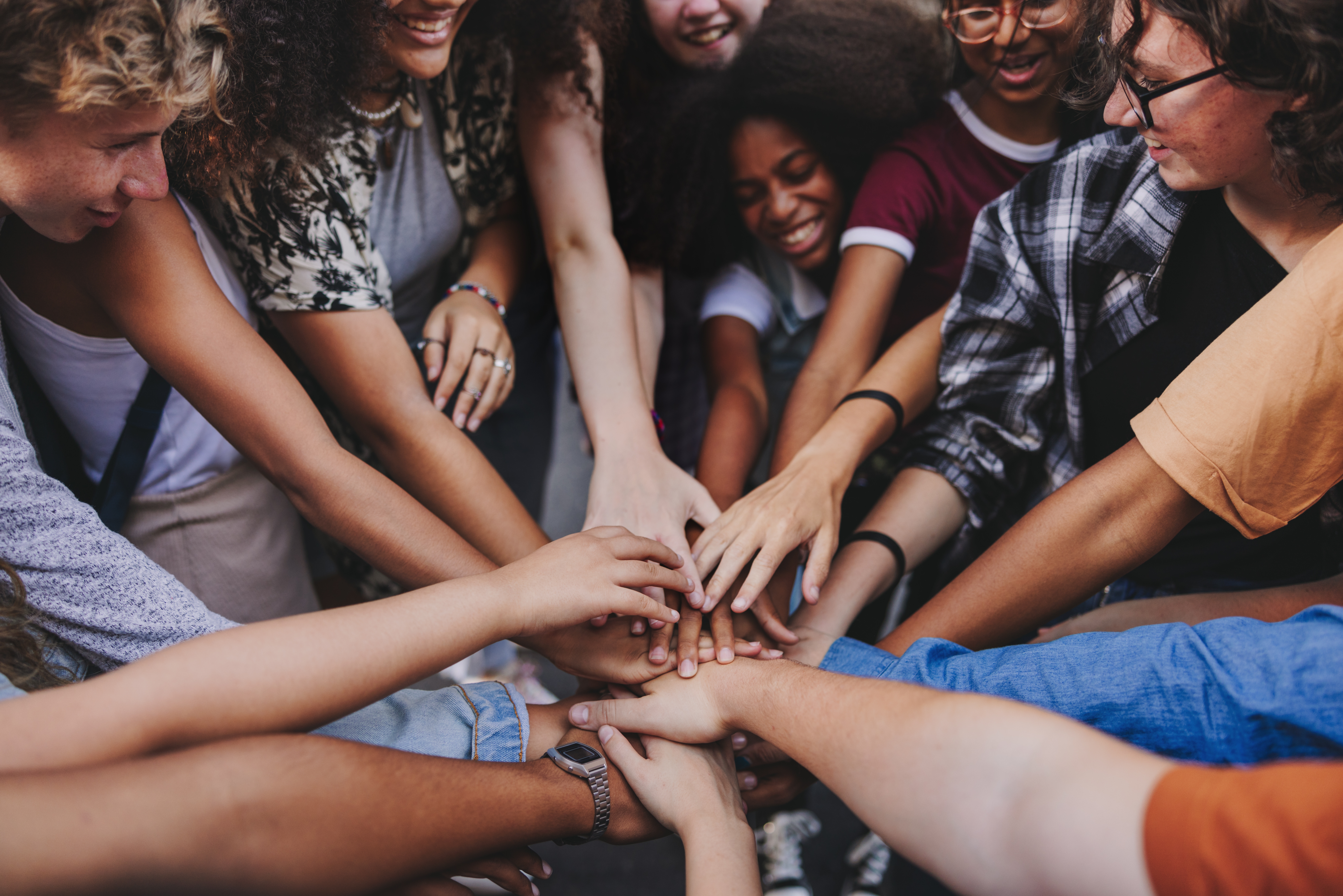 Group of people with hands together in a circle