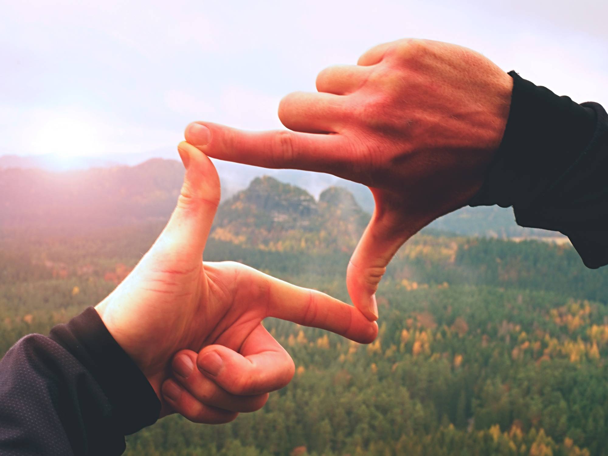 hands making window showing mountains