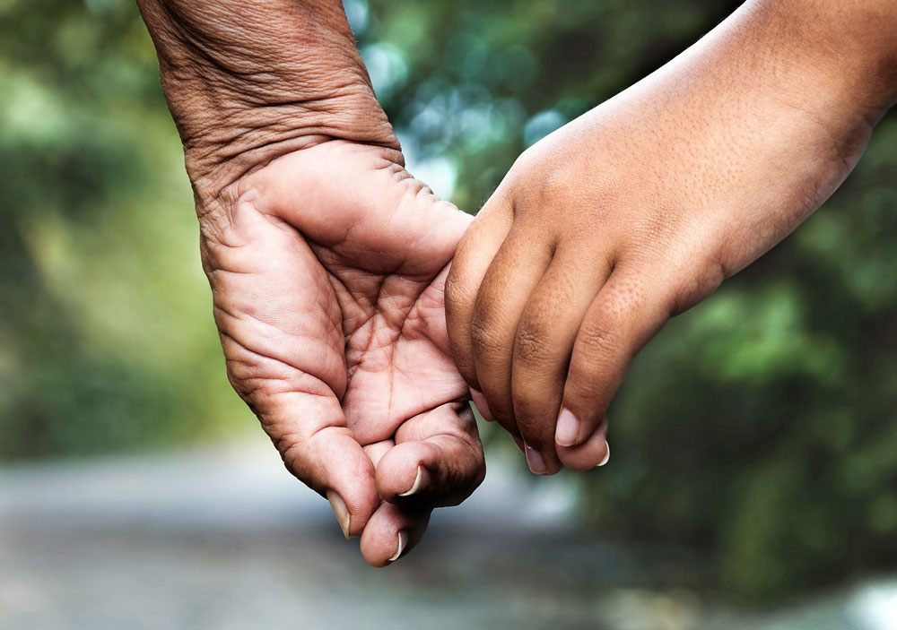 Two hands gently holding each other - one visibly older